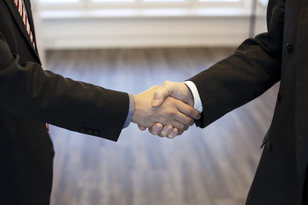 Legal jobs candidate and hiring manager shaking hands in a job interview for executive recruitment and corporate trust